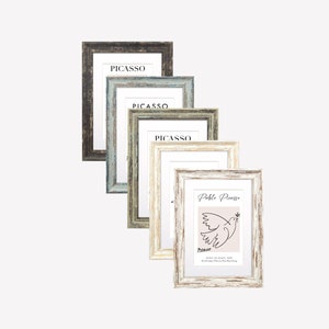 Puede incluir: Cuatro marcos de fotos de diferentes colores con un passe-partout blanco y una impresión de un dibujo de una paloma de la paz de Pablo Picasso dentro del marco.