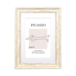 May include: A white wood picture frame with a white mount and a black and white line drawing of a dachshund. The drawing is titled "PICASSO" and the text "THE DACHSHUND MUSEE D'ORSAY RUE DE LA LEGION D'HONNEUR-PARIS" is below the drawing.