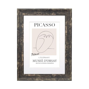 May include: A framed print of a black and white line drawing of an elephant by Pablo Picasso. The print is titled "L'Elephant" and includes the text "Mus&eacute;e d'Orsay" and "Rue de la L&eacute;gion d'Honneur".