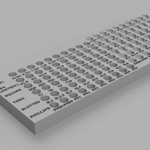 Peut inclure: Un organisateur en plastique gris avec une grille de trous pour ranger différentes tailles de vis et de mèches. L'organisateur est étiqueté pour chaque type de vis, y compris Torx, Hex, Carré, Fente, Phillips et Pozidriv.