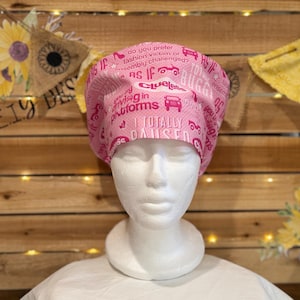 May include: Pink scrub cap with text and car graphics. The cap features phrases like "As If" and "I Totally Paused". The cap is designed for medical professionals or those in the healthcare field.