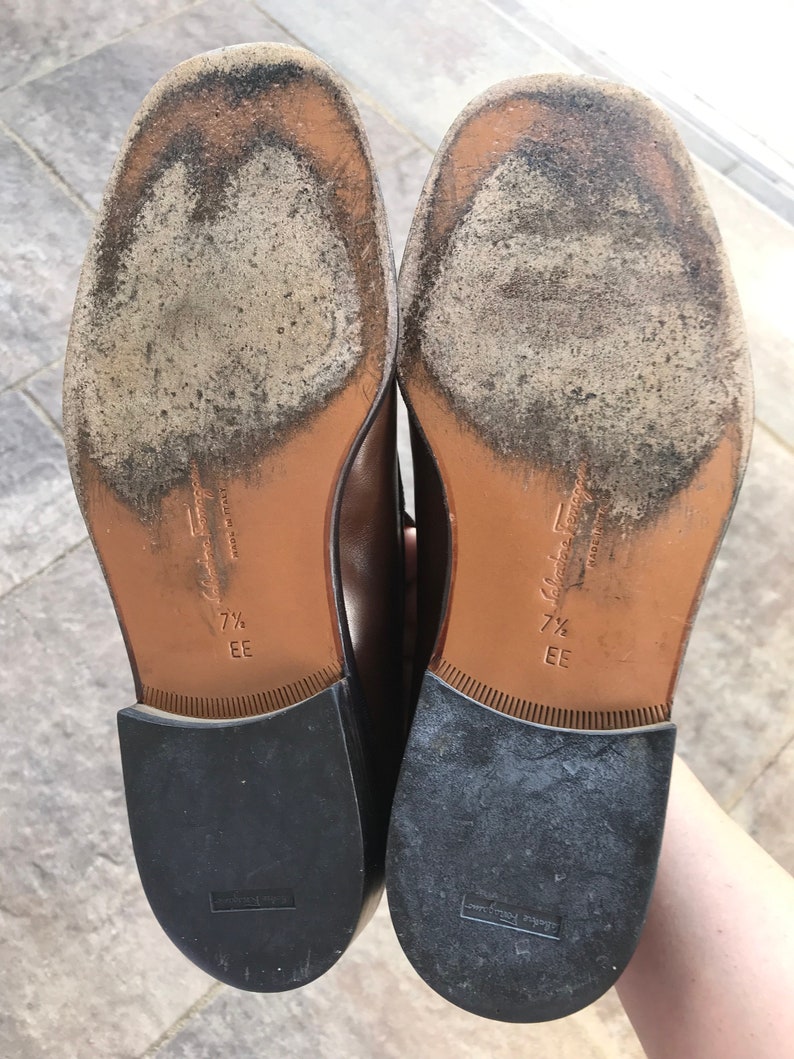 May include: A pair of brown leather shoes with black soles. The shoes are size 7 1/2 EE and are made in Italy.