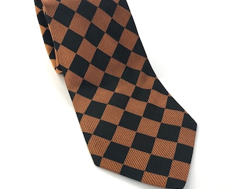 May include: A brown and black checkered tie. The tie has a geometric pattern of squares.
