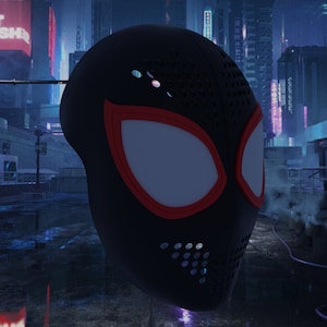 Peut inclure: Un masque de Spider-Man noir et rouge avec une zone oculaire blanche et un motif en maille noire. Le masque est devant un arrière-plan flou d'une ville futuriste.