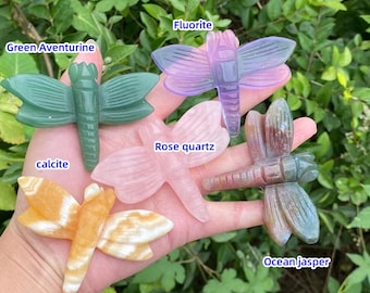 May include: Five dragonfly carvings made of different types of crystals. The carvings are green aventurine, fluorite, rose quartz, calcite, and ocean jasper.