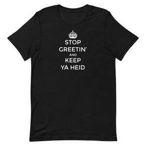 以下が含まれることがあります： 黒いTシャツに白い文字で「STOP GREETIN' AND KEEP YA HEID」と書いてあり、その上に王冠のグラフィックがあります。