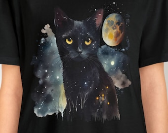 May include: Black t-shirt with a black cat silhouette against a watercolor galaxy background. The cat has yellow eyes and is looking directly at the viewer. A crescent moon with a red and orange gradient is in the background.