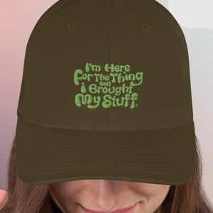 May include: A brown baseball cap with green embroidered text that reads "I'm here for the thing and I brought my stuff."
