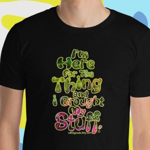 May include: Black t-shirt with a colorful graphic that says "I'm here for the thing and I brought my stuff." The graphic has a psychedelic, tie-dye effect.