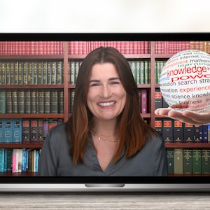 May include: A woman smiles while looking at the camera on a laptop screen. The screen shows a bookshelf behind her and a hand holding a globe with the word "power" in the center surrounded by other words related to knowledge and learning.