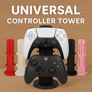 May include: A universal controller tower with the text "UNIVERSAL CONTROLLER TOWER" in white. The tower holds a white and black PlayStation 5 controller and a black Xbox controller. Additional controller stands are red, cream, black, and pink.