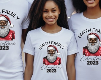 May include: A family of four wearing white t-shirts with a black Santa Claus graphic and the text "Smith Family Christmas 2023".