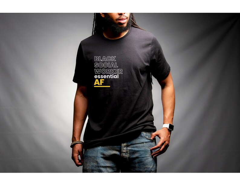 May include: A black t-shirt with white text that reads "Black Social Worker Essential AF" in a stacked format. The text is outlined in black.