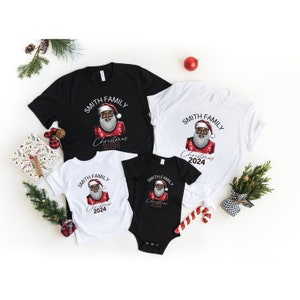 May include: A set of four black and white t-shirts featuring a black Santa Claus graphic. The shirts display the text "Smith Family Christmas 2024".