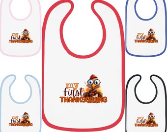 Puede incluir: Un conjunto de cinco baberos para bebé con temática de Acción de Gracias. Los baberos son blancos con ribete rojo y presentan un pavo de dibujos animados con el texto "my first Thanksgiving". Los baberos están disponibles en rosa, azul, azul claro, negro y blanco.