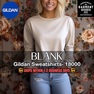 May include: A white Gildan sweatshirt with long sleeves and a crew neck. The sweatshirt is blank and ready to be customized. The text "BLANK Gildan Sweatshirts- 18000" is printed below the sweatshirt. The text "UPS SHIPS WITHIN 1-2 BUSINESS DAYS UPS" is printed below the text.
