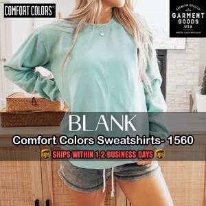 Puede incluir: Una sudadera de color azul claro con el texto "BLANK" y "Comfort Colors Sweatshirts - 1560" impreso en ella. El texto "SHIPS WITHIN 1-2 BUSINESS DAYS" tambi&eacute;n est&aacute; impreso en la imagen.