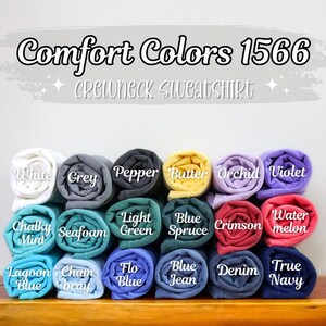 Puede incluir: Una variedad de sudaderas con cuello redondo Comfort Colors 1566 enrolladas en diferentes colores, incluyendo blanco, gris, pimienta, mantequilla, orqu&iacute;dea, violeta, menta blanquecina, espuma de mar, verde claro, azul abeto, carmes&iacute;, sand&iacute;a, azul laguna, gris champ&aacute;n, azul flo, azul vaquero, denim y azul marino.