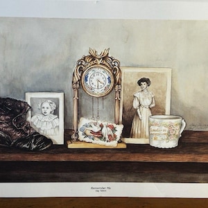 Peut inclure: Une estampe aquarelle intitulée "Remember Me" représente une étagère avec une horloge vintage, des portraits encadrés, une botte et une tasse à thé. L'horloge est dorée et les portraits sont de femmes. La tasse à thé a des motifs floraux.