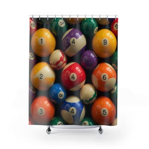 Op de afbeelding: Douchegordijn met een close-up van verschillende biljartballen. De ballen zijn genummerd van 1 tot en met 9 en hebben tinten geel, oranje, rood, blauw, groen en paars. Het gordijn is op een rail gemonteerd.