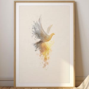 Puede incluir: Una impresión en acuarela enmarcada de una paloma en vuelo. La paloma está representada con un degradado de colores, que va del gris al amarillo. El fondo es de un color blanco roto suave y el marco es de madera clara.