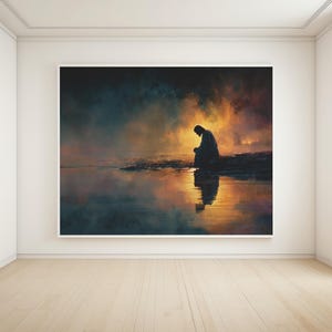 May include: A large framed art print shows a silhouetted figure seated near water, with a reflective surface. The artwork features a warm, golden glow in the background, contrasting with the darker foreground and figure. The overall theme is contemplative.