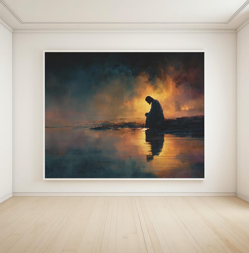 May include: A large framed art print shows a silhouetted figure seated near water, with a reflective surface. The artwork features a warm, golden glow in the background, contrasting with the darker foreground and figure. The overall theme is contemplative.