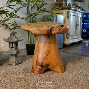 May include: A handcrafted wooden side table with a natural, organic shape. The table is made from a single piece of wood, showcasing the grain and texture. The table is approximately 20 inches tall and 18 inches wide.