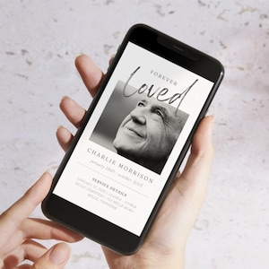 May include: A smartphone displaying a digital memorial card with a black and white photo of a man. The card reads "Forever Loved" and includes the name "Charlie Morrison" and service details.