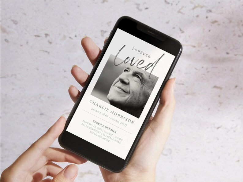 May include: A smartphone displaying a digital memorial card with a black and white photo of a man. The card reads "Forever Loved" and includes the name "Charlie Morrison" and service details.