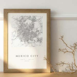 Può includere: Una stampa artistica da parete incorniciata con una dettagliata mappa stradale in grigio e bianco di Città del Messico. La stampa include il testo MEXICO CITY seguito dalle coordinate 19.43 N / 99.13 W e la parola MEXICO in un font nero pulito.