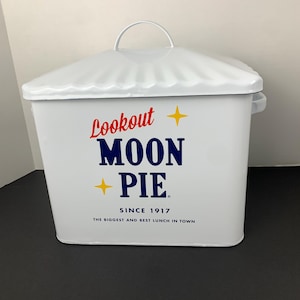 May include: White metal container with a lid and handle. The container features the text "Lookout Moon Pie" in red and blue, with yellow star accents. The text "Since 1917" and "The Biggest and Best Lunch in Town" are also visible.