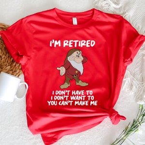 May include: Red t-shirt with a white graphic of a cartoon dwarf with a beard and the text "I'm Retired I don't have to I don't want to You can't make me".