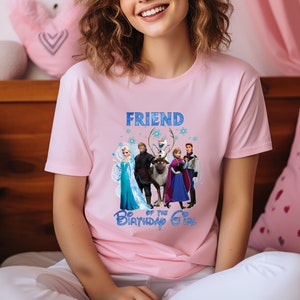 May include: Pale pink t-shirt with a graphic of characters from the animated film Frozen. The text "FRIEND of the BIRTHDAY GIRL" is printed in blue. The shirt is made of a soft material.