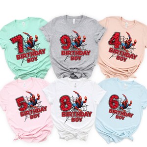 May include: Six different t-shirts featuring a Spiderman graphic with a number and the text "Birthday Boy". The shirts are in various colors, including light blue, light pink, white, gray, and light green.
