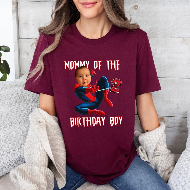 Puede incluir: Camiseta color burdeos con el texto "Mommy of the 2 Birthday Boy" en negro. Una foto de un beb&eacute; se superpone a la cabeza de un Spiderman de dibujos animados.