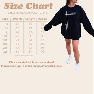 Op de afbeelding: Maattabel voor een Gildan 18000 sweatshirt, met afmetingen in inches voor maten S tot en met 5XL. De tabel bevat breedte-, lengte- en mouwmaten. De tekst adviseert om een maat groter te nemen.