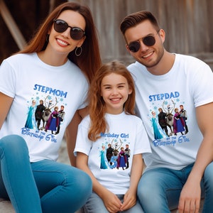 May include: Three people wearing white t-shirts with a blue graphic featuring characters from the movie Frozen. The shirts read "Stepmom of the Birthday Girl", "Birthday Girl", and "Stepdad of the Birthday Girl". The family is smiling.