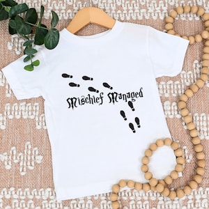 May include: White t-shirt with a black graphic of footprints and the text "Mischeif Managed".