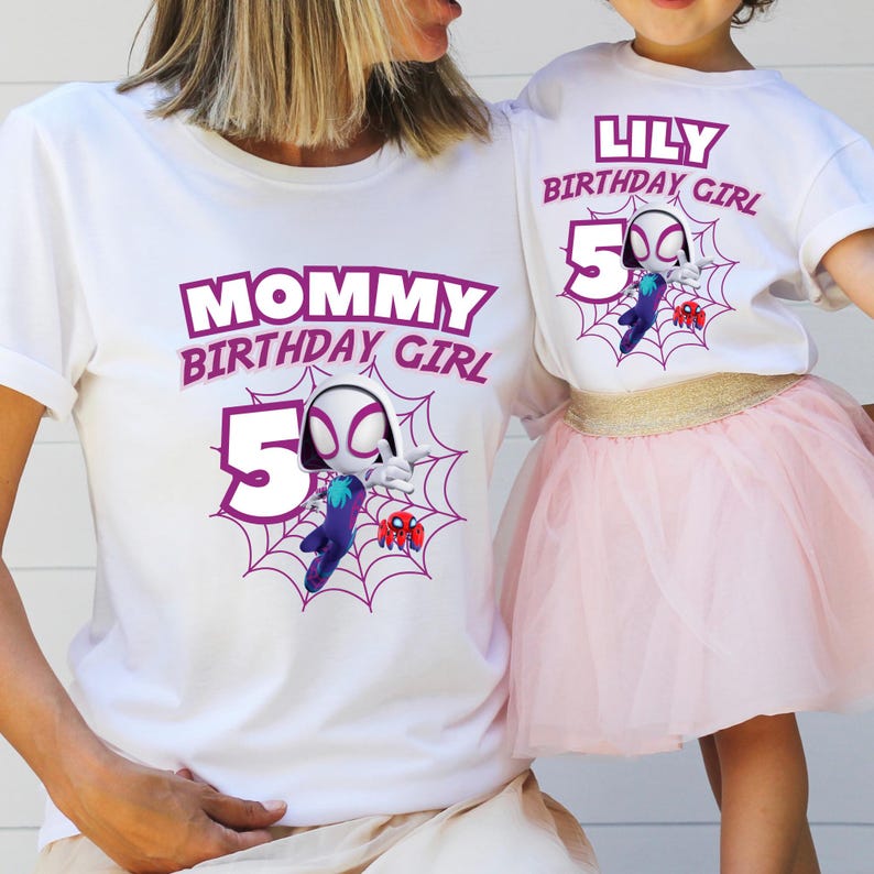 Pu&ograve; includere: Magliette bianche con grafica coordinata. Una maglietta recita "MOMMY BIRTHDAY GIRL" e l'altra "LILY BIRTHDAY GIRL". Entrambe le magliette presentano una grafica a tema ragno con il numero 5 e un disegno a ragnatela.