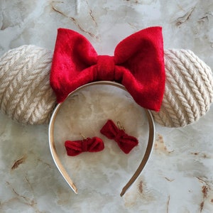 Knitted sweater ears with red velvet bow.