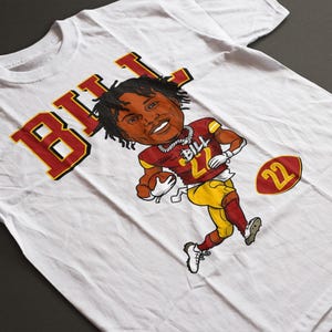 May include: White t-shirt with a cartoon illustration of a football player in a maroon and gold uniform. The name "BILL" is in large letters. The player is holding a football, and the number "22" is visible.