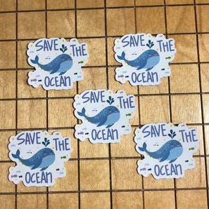 May include: Five blue whale stickers with the text "Save the Ocean" and a small illustration of a whale with seaweed and fish.