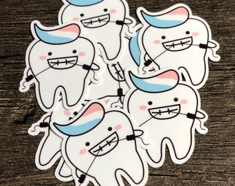 May include: A set of five white tooth stickers with blue and pink toothpaste on top. Each tooth has black braces and is holding a black floss string.