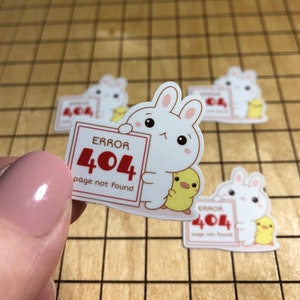 May include: A white bunny sticker with a yellow chick holding a sign that says "ERROR 404 page not found".