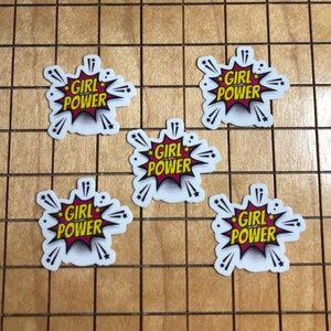 May include: Five white stickers with a red and yellow comic book style speech bubble design. The text inside the speech bubble says "Girl Power".