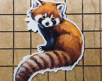 May include: A watercolor illustration of a red panda with a curled tail. The red panda is sitting on its haunches with its front paws tucked in. The background is a light brown wood grain.