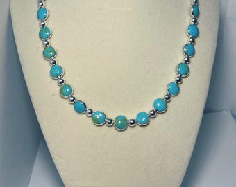 Puede incluir: Un collar de turquesa y plata con piedras redondas de turquesa y cuentas de plata.