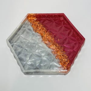 May include: A hexagonal tray with a white and burgundy resin design. The tray has a metallic gold accent and a geometric pattern.