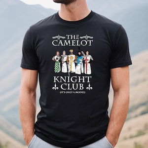 May include: Black t-shirt with a graphic of five knights in armor. The text reads "The Camelot Knight Club (It's only a model)"